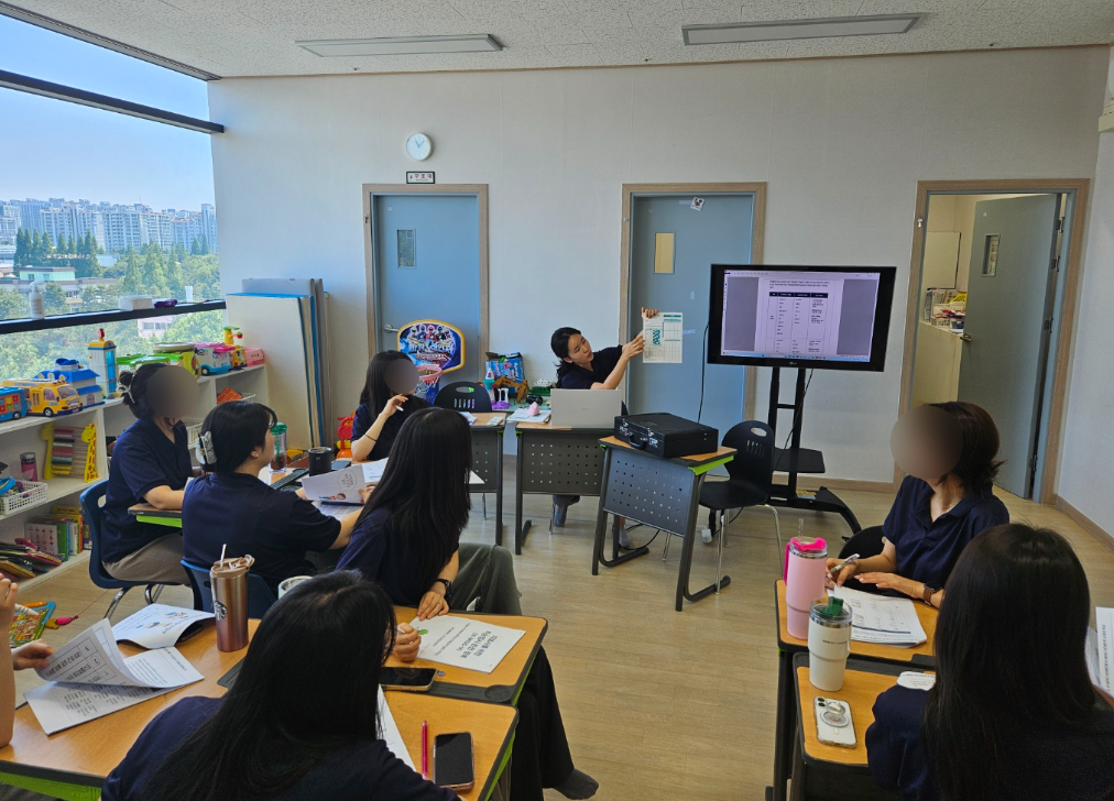 치료사들이 모여 아이의 관찰 기준을 함께 확인하는 교육 장면. 얼굴은 모자이크 처리됨